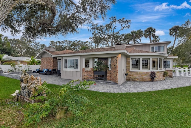 back of property featuring a lawn and a patio area