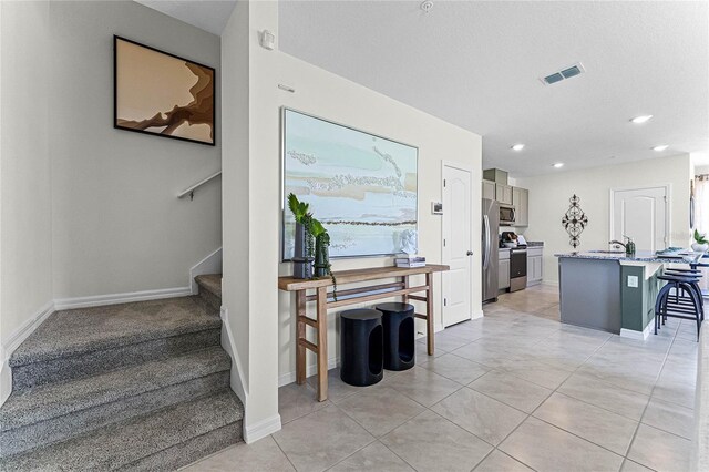 staircase with tile patterned flooring and sink