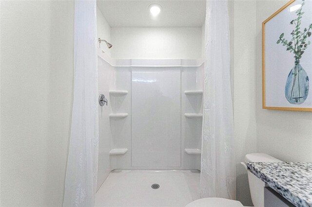 bathroom with a shower with shower curtain, vanity, and toilet