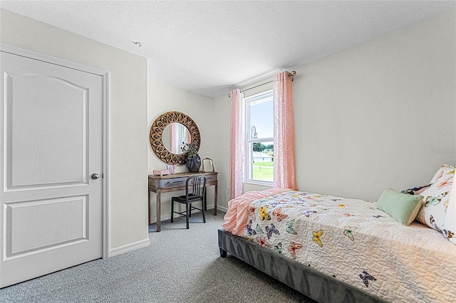 bedroom with a textured ceiling and carpet