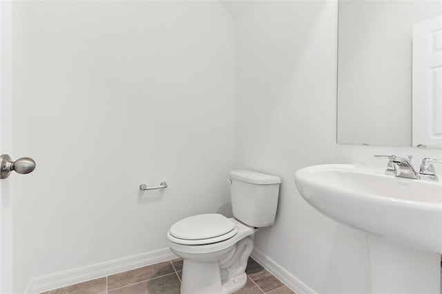 bathroom featuring sink, toilet, and tile patterned flooring