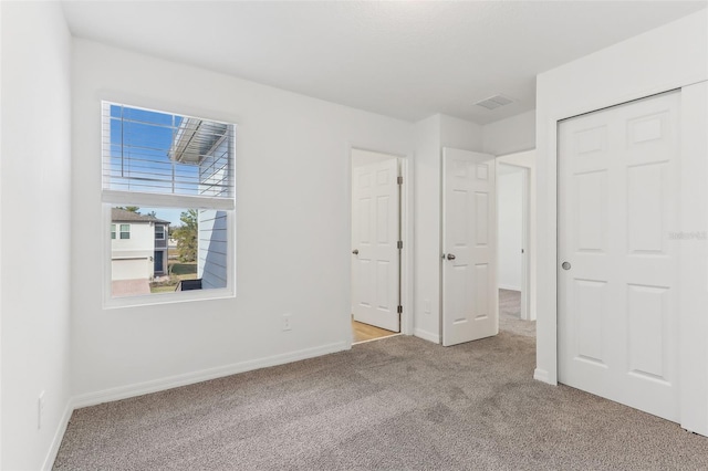 unfurnished bedroom featuring a closet and light carpet