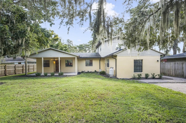 rear view of property with a lawn and covered porch