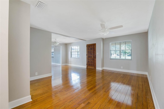 unfurnished room featuring hardwood / wood-style flooring, a healthy amount of sunlight, and ceiling fan