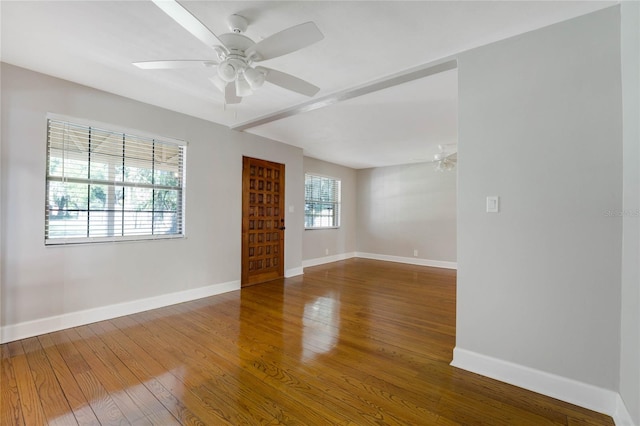 unfurnished room with hardwood / wood-style flooring, a healthy amount of sunlight, and ceiling fan