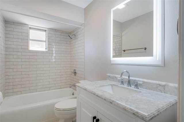 full bathroom featuring tiled shower / bath combo, vanity, and toilet