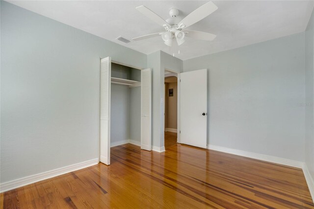 unfurnished bedroom featuring hardwood / wood-style flooring, ceiling fan, and a closet