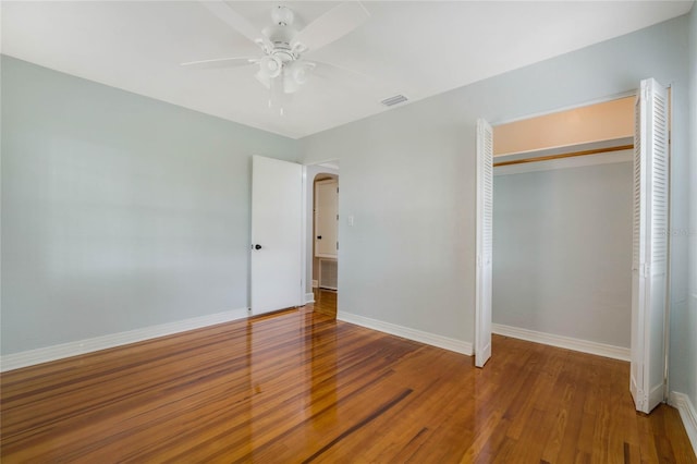 unfurnished bedroom featuring a closet, hardwood / wood-style flooring, and ceiling fan