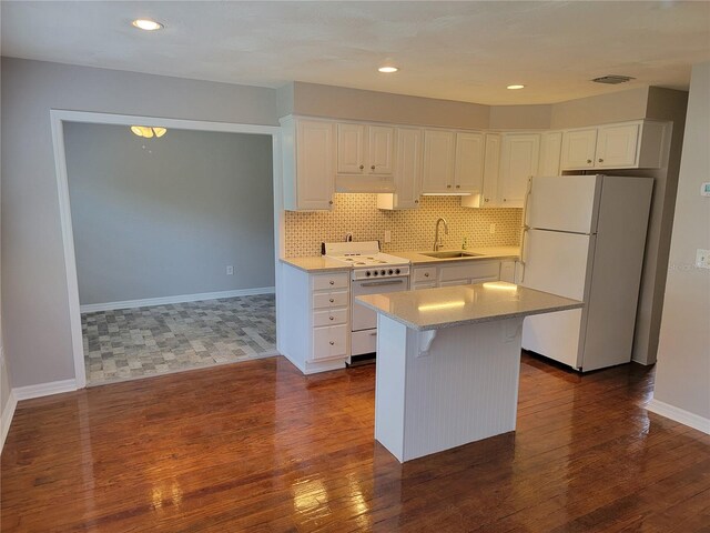 kitchen featuring a kitchen island, dark hardwood / wood-style flooring, white appliances, and white cabinetry