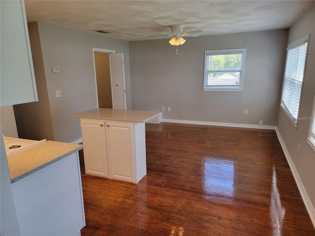 5625 Chipola Cir, Orlando, FL 32839 - kitchen featuring dark wood finished floors, ceiling fan, white cabinetry, baseboards, and a kitchen island