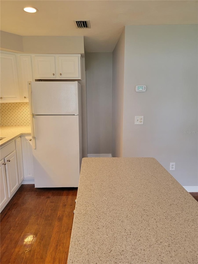 kitchen featuring tasteful backsplash, white refrigerator, white cabinetry, and dark hardwood / wood-style flooring