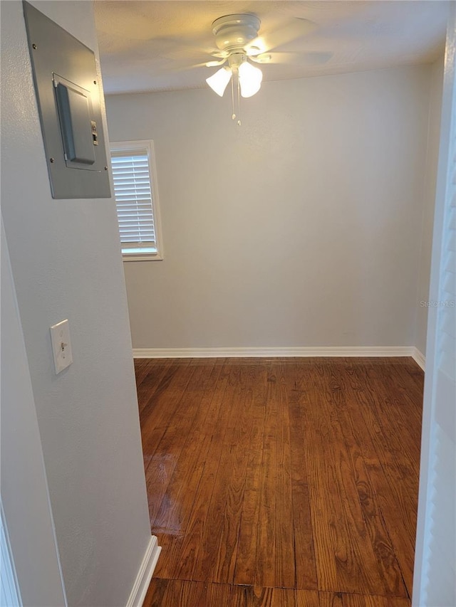 empty room with hardwood / wood-style flooring, ceiling fan, and electric panel