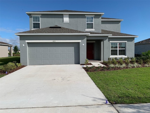 traditional home with stucco siding, concrete driveway, and a front yard