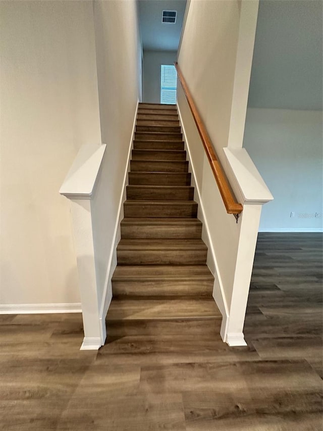 stairs featuring wood finished floors and baseboards