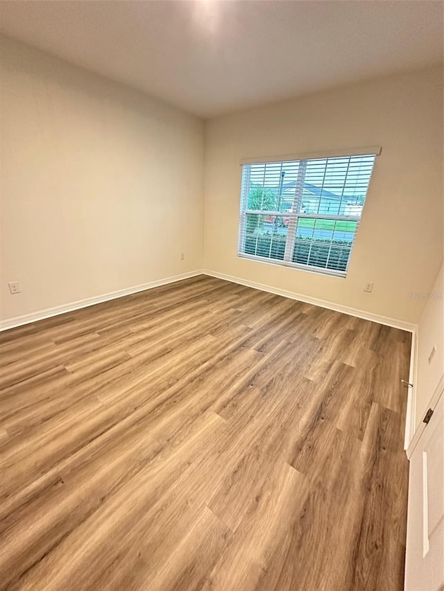 spare room featuring wood finished floors and baseboards