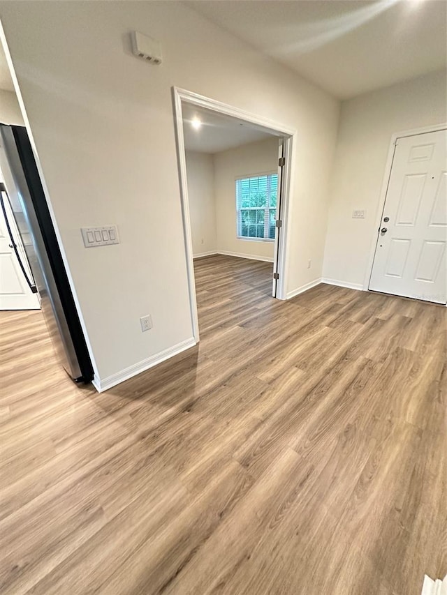 spare room with light wood finished floors and baseboards