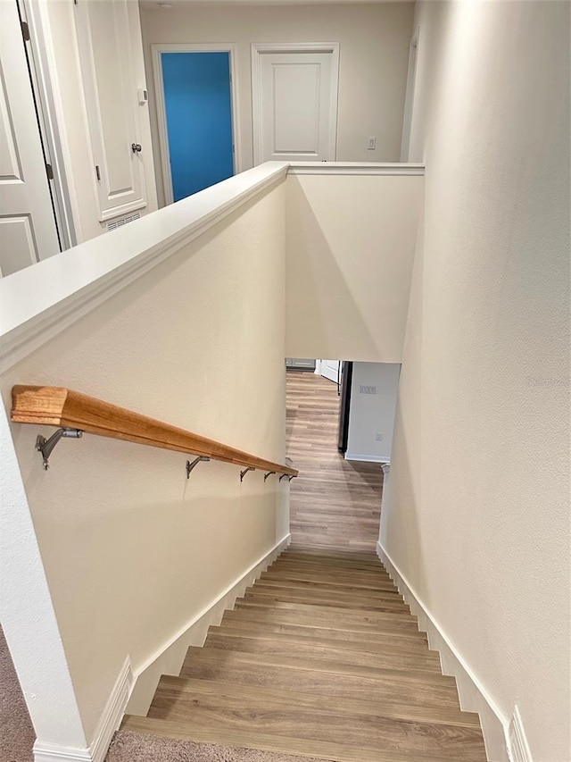 stairs featuring wood finished floors and baseboards