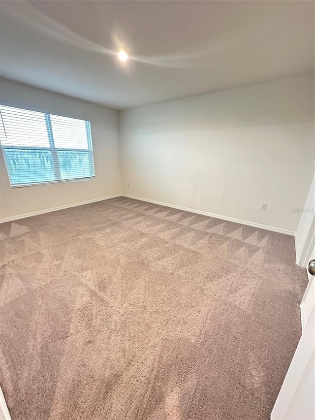 empty room with carpet and baseboards