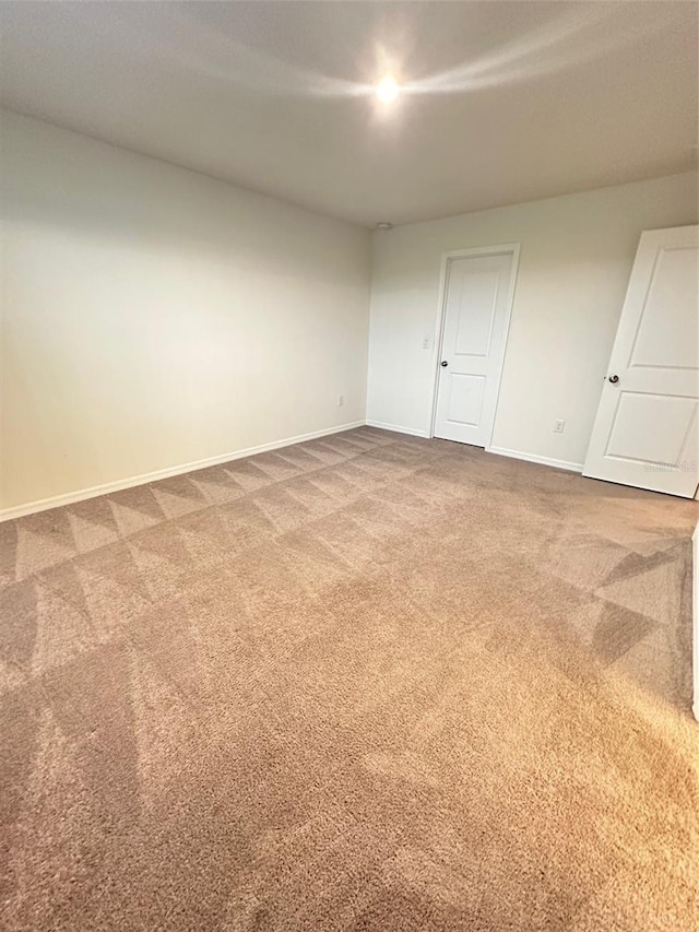 carpeted spare room featuring baseboards