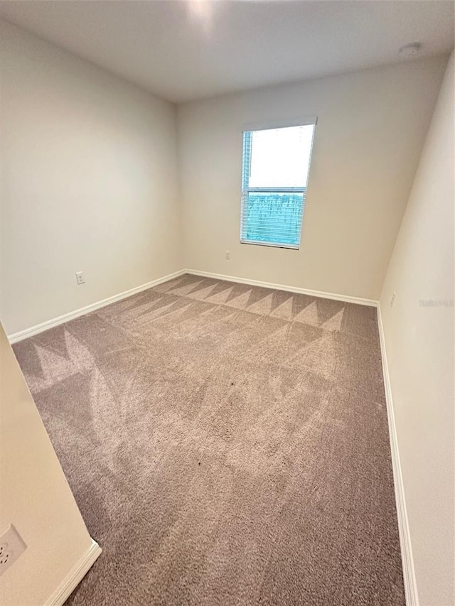 carpeted empty room with baseboards