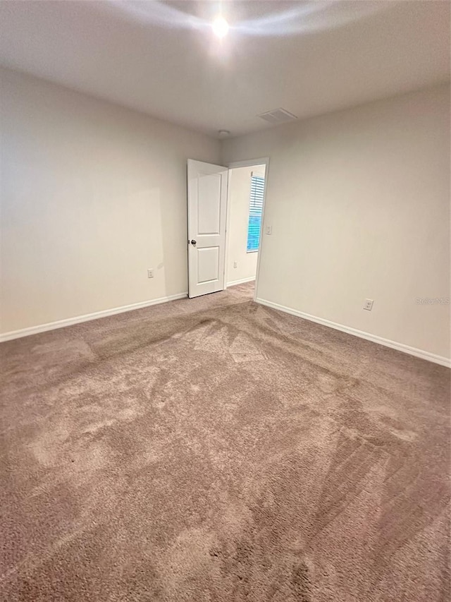 unfurnished room featuring visible vents, baseboards, and carpet floors