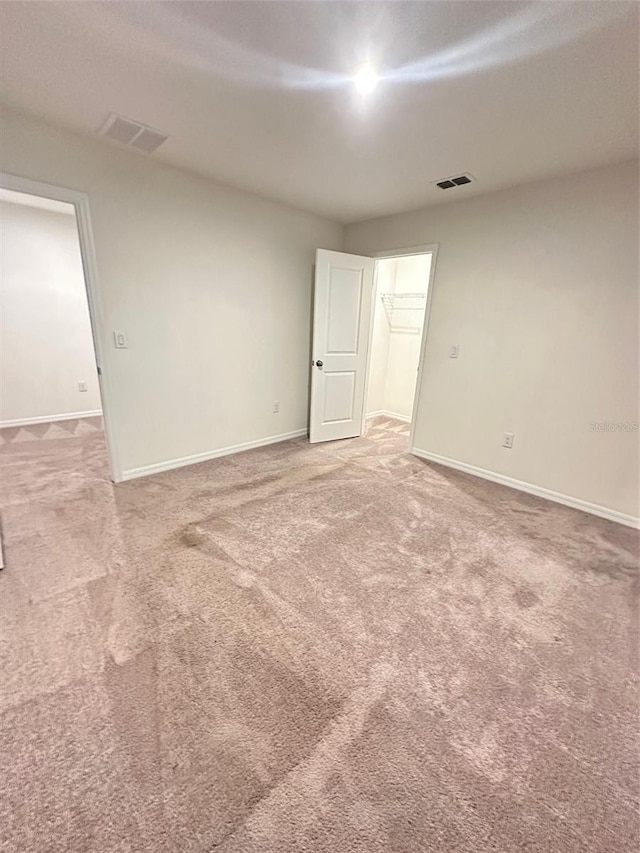 unfurnished room with visible vents, carpet, and baseboards