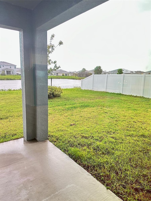 view of yard with fence and a water view