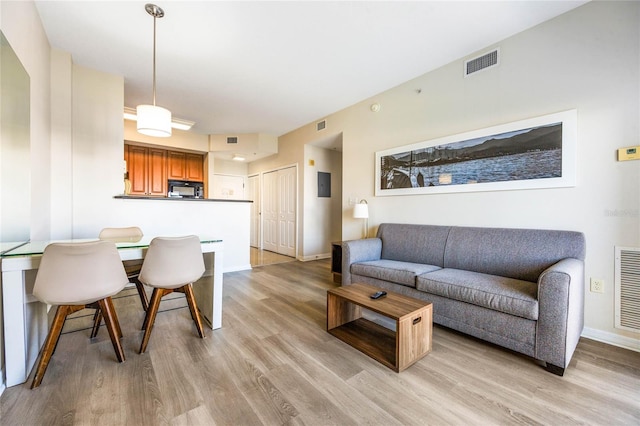 living room with electric panel and light hardwood / wood-style floors