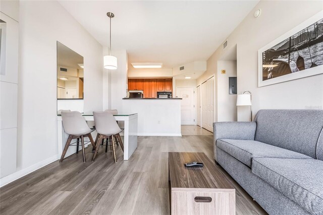 7383 Universal Blvd Unit 710, Orlando, FL 32819 - living room featuring baseboards, electric panel, light wood-style flooring, and visible vents