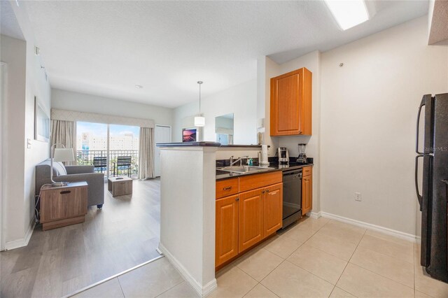 7383 Universal Blvd Unit 710, Orlando, FL 32819 - kitchen featuring dark countertops, a sink, black appliances, a peninsula, and open floor plan