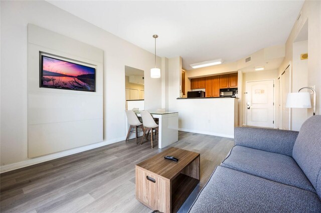 7383 Universal Blvd Unit 710, Orlando, FL 32819 - living room with visible vents, light wood finished floors, and baseboards