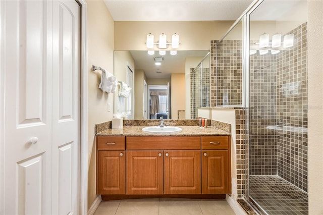 bathroom with vanity, a shower with door, and tile patterned floors