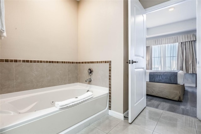 bathroom with a tub to relax in and tile patterned floors