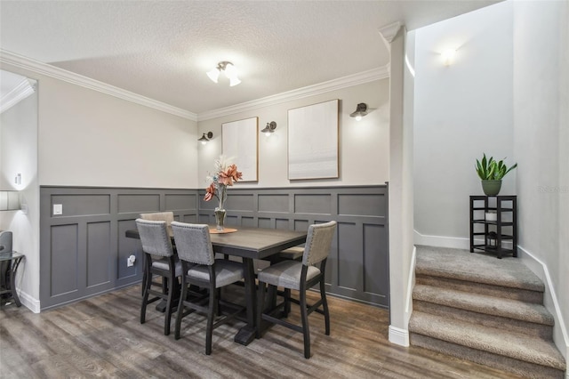 dining space featuring ornamental molding, a textured ceiling, and dark hardwood / wood-style flooring