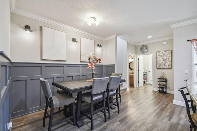 dining area with a textured ceiling, ornamental molding, and dark hardwood / wood-style floors