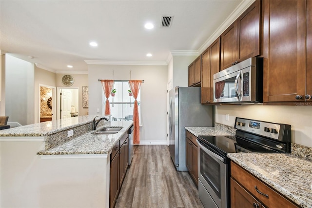 kitchen with ornamental molding, sink, stainless steel appliances, dark hardwood / wood-style floors, and light stone countertops