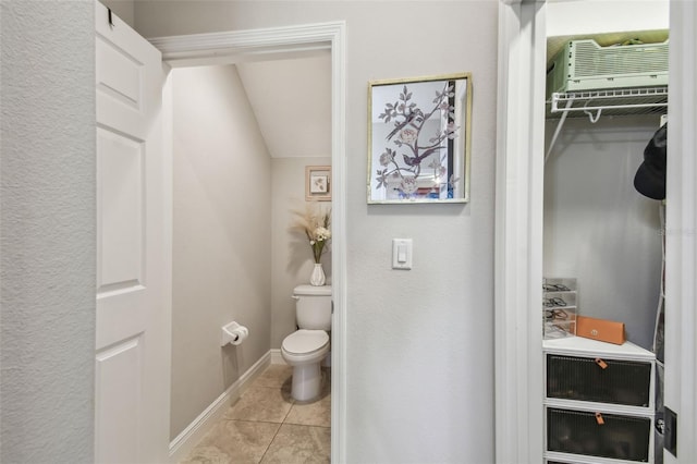 bathroom featuring lofted ceiling, toilet, and tile patterned floors