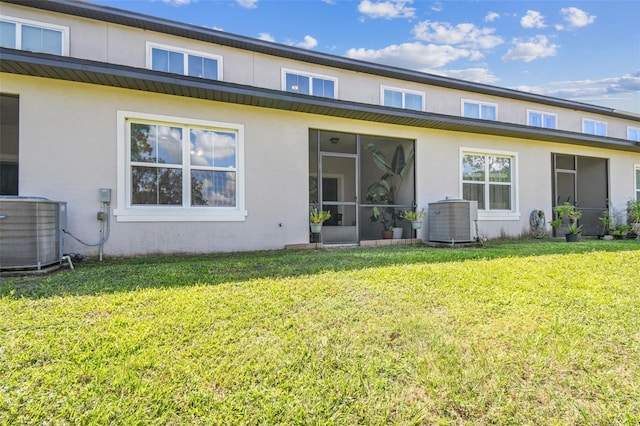 rear view of property with a sunroom, a lawn, and central air condition unit