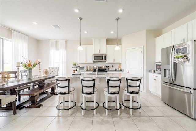 kitchen featuring appliances with stainless steel finishes, a healthy amount of sunlight, light stone counters, and white cabinets