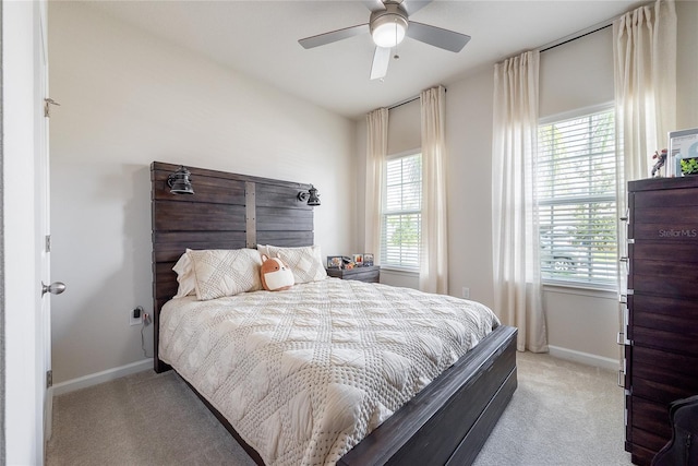 carpeted bedroom featuring ceiling fan and multiple windows