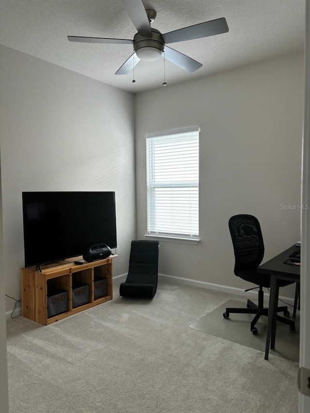 carpeted office space with ceiling fan