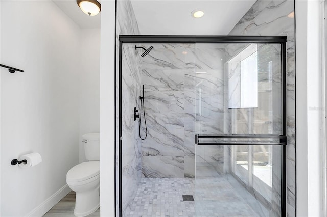 bathroom with hardwood / wood-style floors, toilet, and an enclosed shower