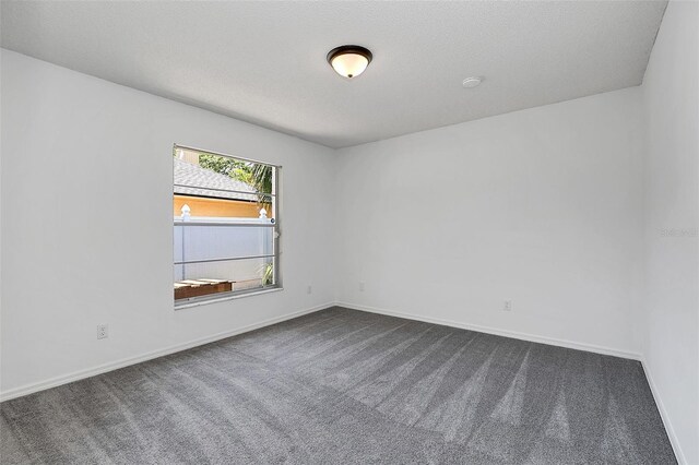 carpeted empty room with a textured ceiling