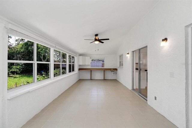 unfurnished sunroom with vaulted ceiling, ceiling fan, and a healthy amount of sunlight