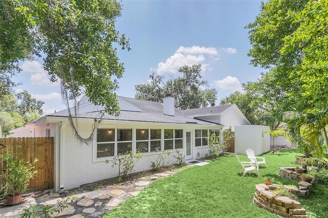 rear view of house featuring a yard