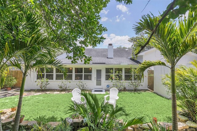 rear view of property featuring a yard