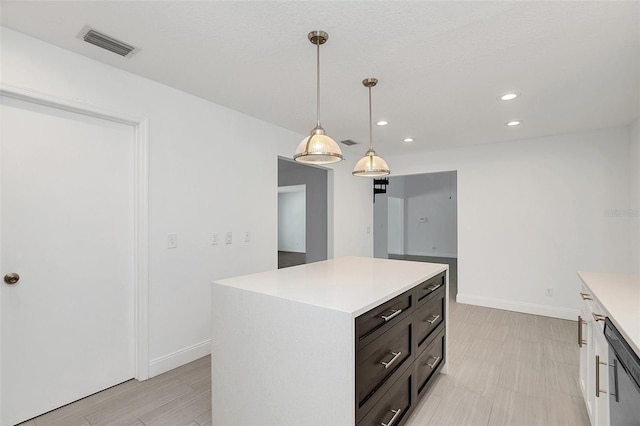 kitchen with stainless steel dishwasher, decorative light fixtures, a center island, and white cabinetry