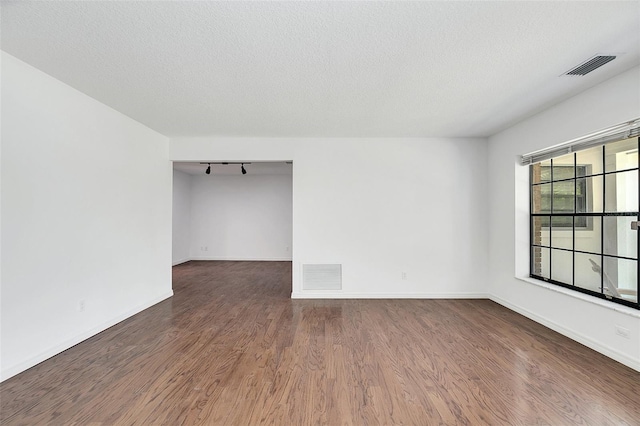 unfurnished room with a textured ceiling and hardwood / wood-style flooring