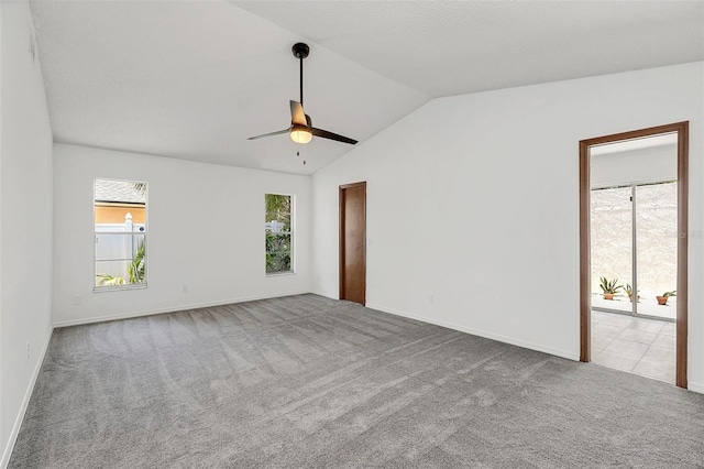 spare room with light carpet, ceiling fan, and vaulted ceiling