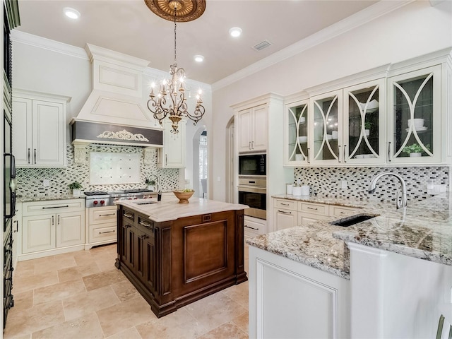 kitchen with decorative backsplash, a center island with sink, appliances with stainless steel finishes, and sink